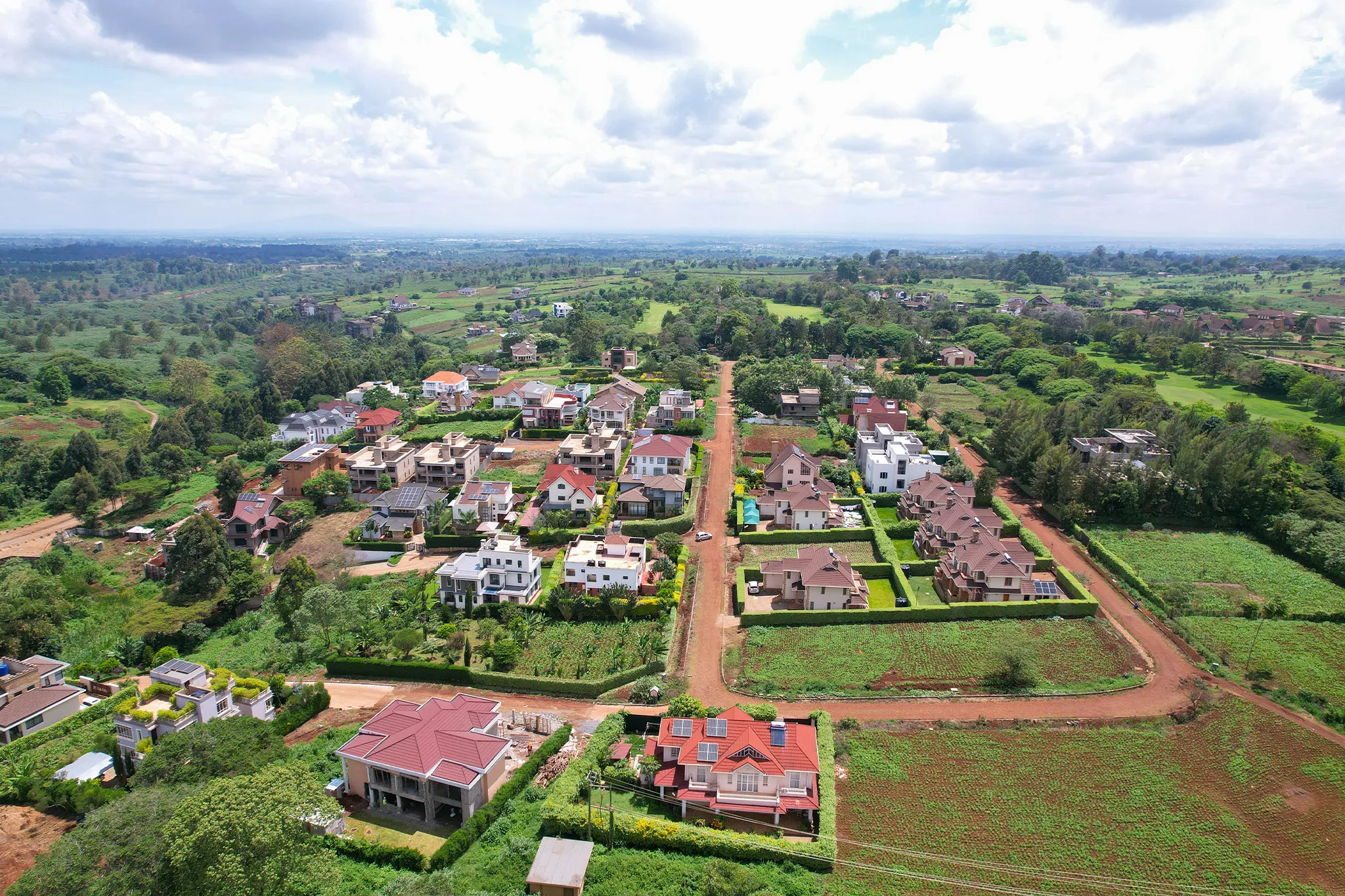 Main estate road lined with residential homes — Migaa Golf Estate aerial photography